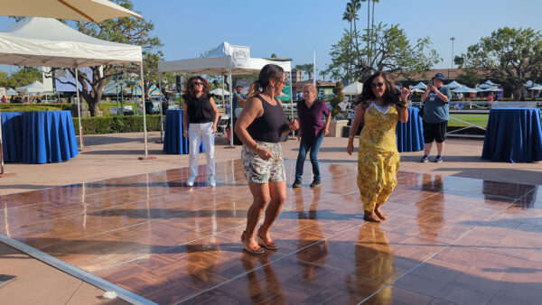a group of people on a dance floor with booths in the background