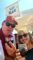 a man in a USC hat and a woman holding glass of wine standing by a sign reading VIP Bar