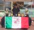 a man in black behind a booth decorated with the Italian flag