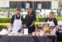 two women standing with a man in a white apron behind a booth for Cabrera's