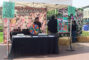 a booth for Santa Anita park featuring a floral banner and spinning wheel