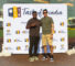 two men standing in front of a Taste of Arcadia step and repeat banner, and one man is holding up a peace sign
