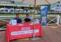 a booth with two men behind it and a red ReMax table cloth on it reading Steven Rhee
