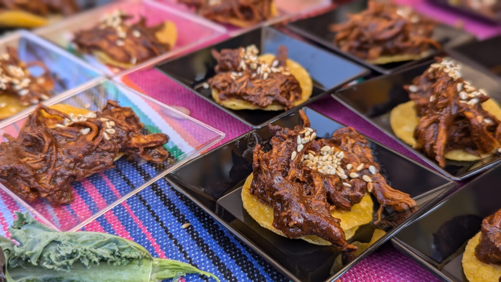 plates of shredded meat on chips set in rows on black and clear plates
