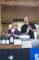 a woman and a man holding up bottles of wine with a wine display in front of them