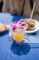 a cocktail in a plastic cup with a purple orchid flower in it