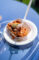 a plate of fried chicken in a paper container with a fork stuck in it