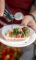 caprese salad on a stick being drizzled with balsamic vinegar