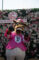 a person in a horse costume standing in front of a flower wall holding up their hooves
