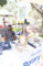 a woman and a man seated behind a table set with items from the Rotary Club