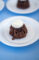 a chocolate bundt cake with white icing on a white plate