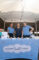 a group of three women behind a table set with a blue Nothing Bundt Cakes logo