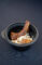 a bbq-ed rib in a bowl of noodles