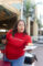 a woman in a red USC Arcadia Hospital shirt holding out a burger