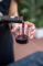 a glass of wine being poured and held by a hand with red nails