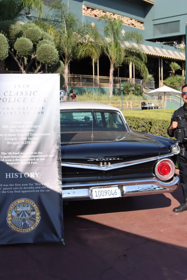 a man in police uniform stands beside a vintage police car
