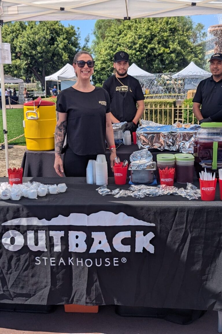 a group of people at a booth for Outback at Taste of Arcadia