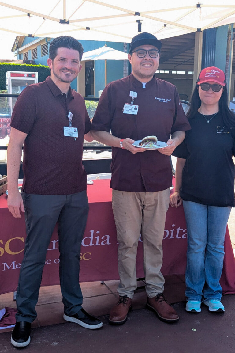 a woman and two men at the booth for USC Arcadia Hospital at Taste of Arcadia