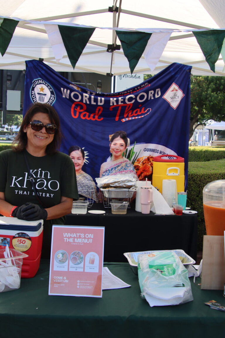 a woman behind a booth for Kin Khao Thai Eatery at Taste of Arcadia