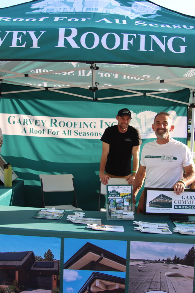 three men in a booth for Garvey Roofing at Taste of Arcadia