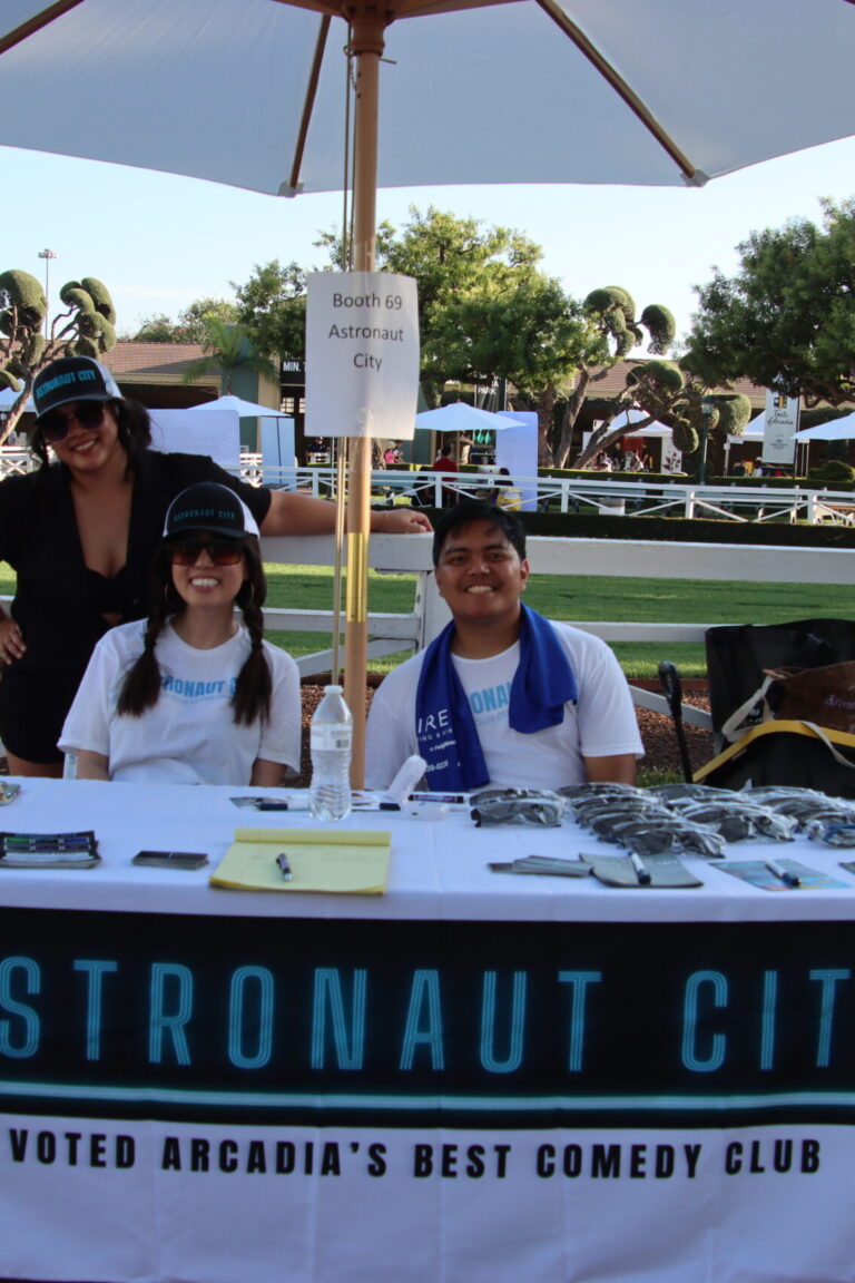 two women and a man behind a booth for Astronaut City at Taste of Arcadia