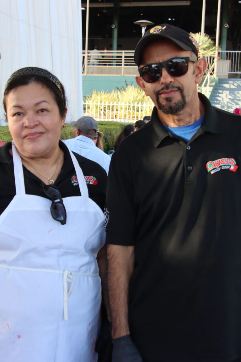 a woman in a white apron with a man in a black Cabrera's shirt at Taste of Arcadia