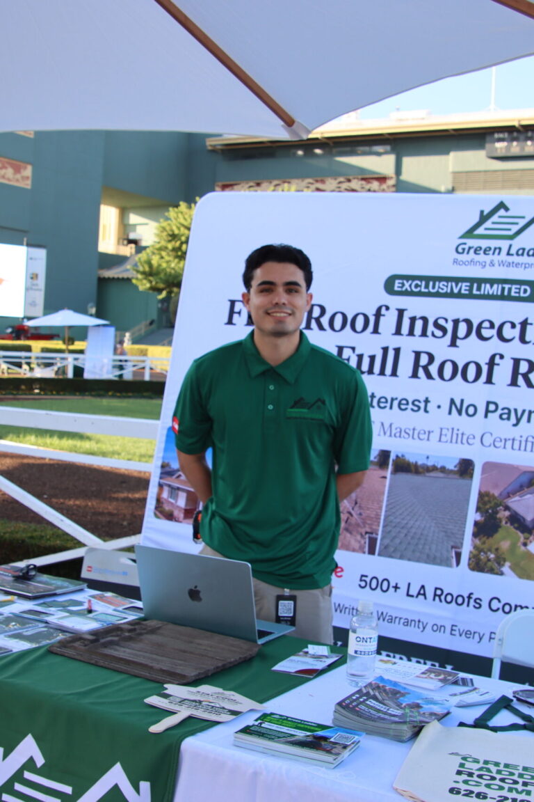 a man behind a booth for Green Ladder Roofing at Taste of Arcadia