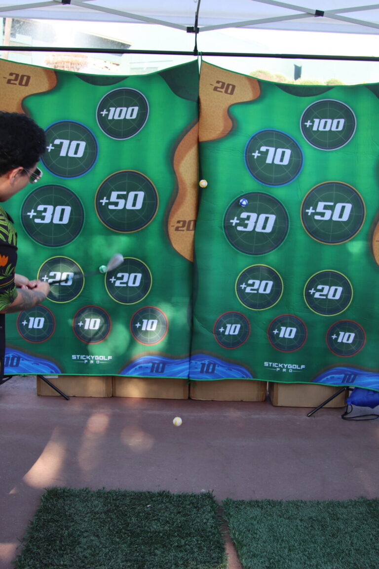 a person playing golf at the Topgolf booth at Taste of Arcadia