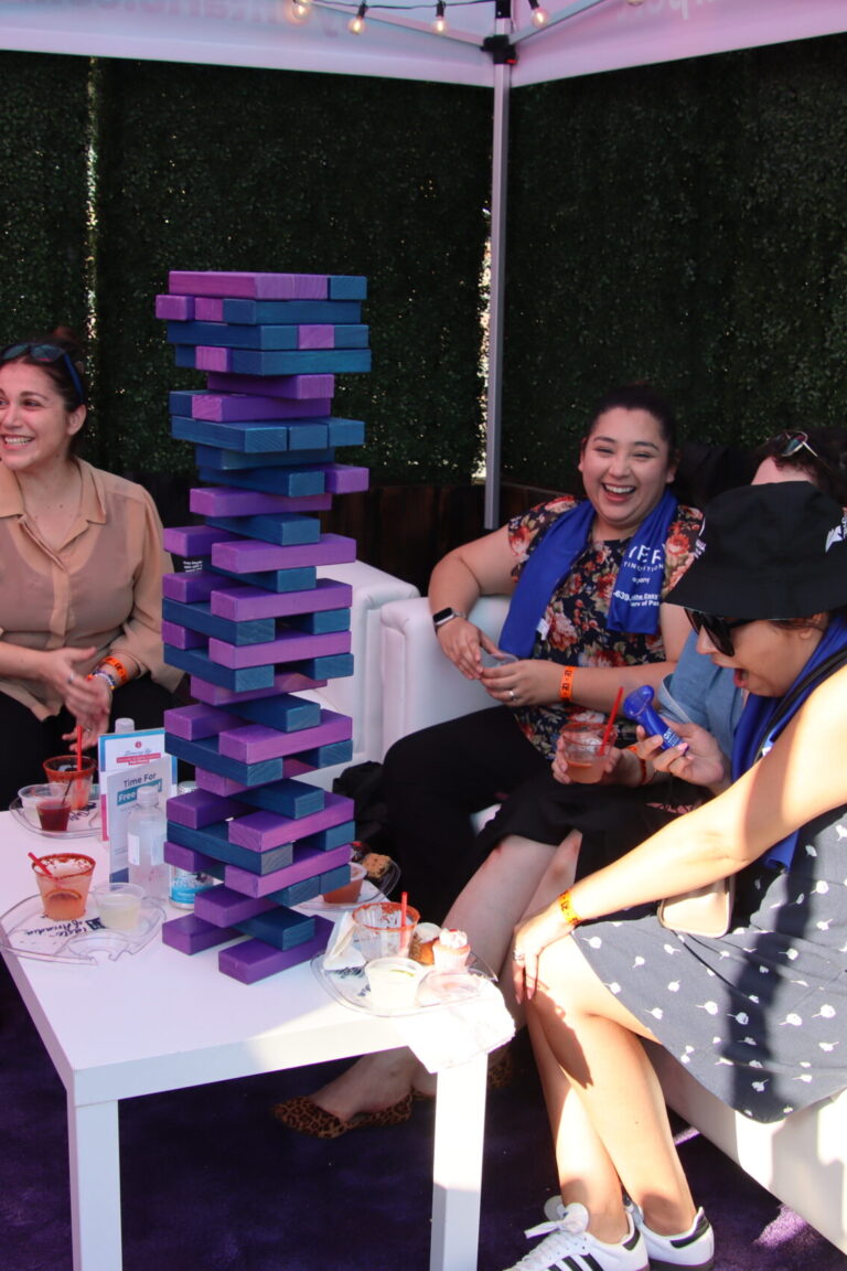 a group of women playing oversized jenga at the Ontario Airport booth at Taste of Arcadia
