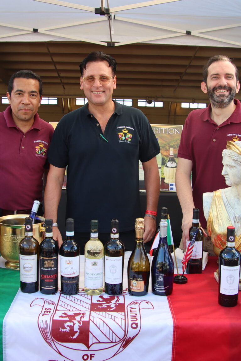 three men standing behind a table set with D'Aquino wine bottles at Taste of Arcadia