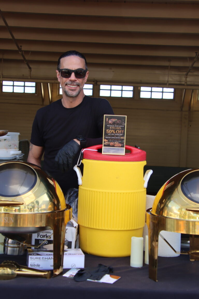 a man standing behind gold chafing dishes with Domenico's at Taste of Arcadia