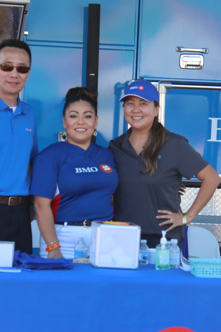 two women and a man standing in front of the BMO Bank bus at Taste of Arcadia
