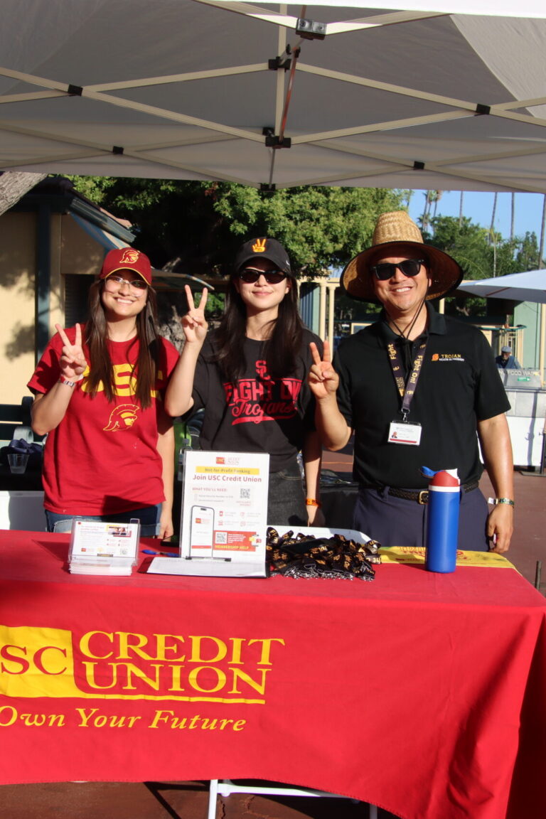 two women and a man behind a booth for USC Credit Union at Taste of Arcadia
